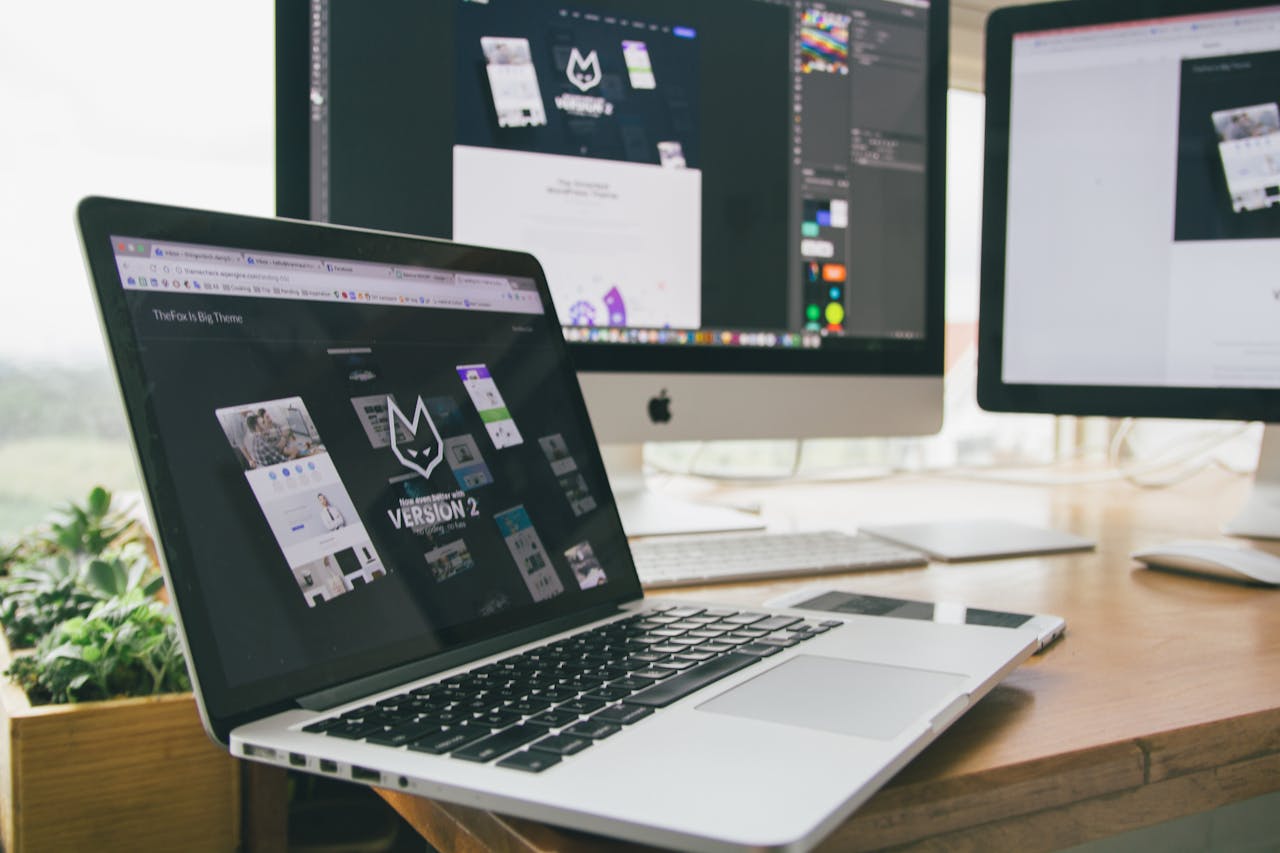 heros-img A stylish workspace featuring a laptop and monitors displaying design software.